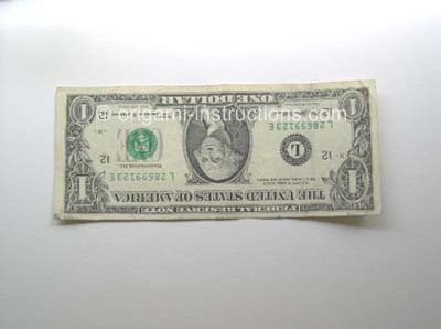 dollar bill ready to fold into origami elephant
