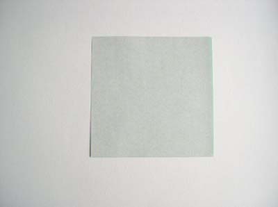 square of green origami paper ready to fold